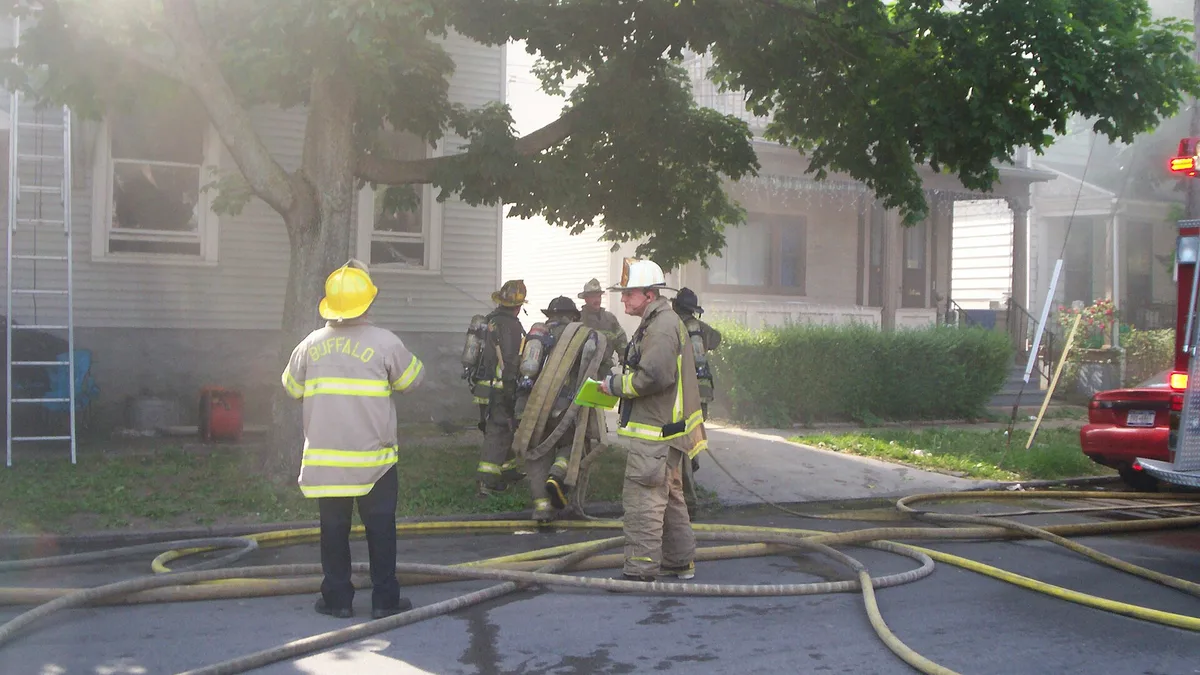 Firefighters bring hoses to an apartment building fire (file photo, Buffalo, N.Y., 2007; not the Aberdeen fire)